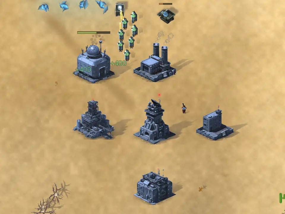 The same base seen from above on open desert: pale gold sand with dry scrub and a faint dune line running across it. Blue ore crystals and a truck sit at the upper left with a column of green-marked infantry beside them, and green +400 markers float over the base.